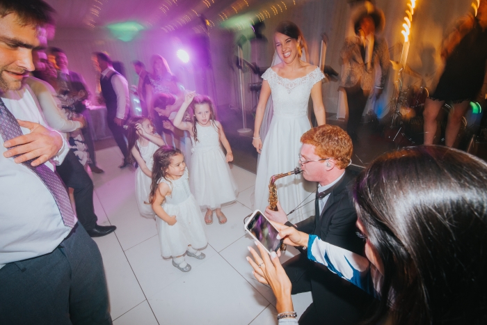 Saxophonist playing to guest on dance floor